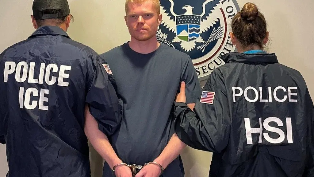 Immigration officials, their backs turned to hide their identities, pose with an Australian citizen who faces possible deportation back to his home country. A list of “sanctuary” jurisdictions accused of failing to cooperate with immigration arrests, including the state of Colorado, was taken down after protests about its accuracy. (Photo by U.S. Immigration and Customs Enforcement)