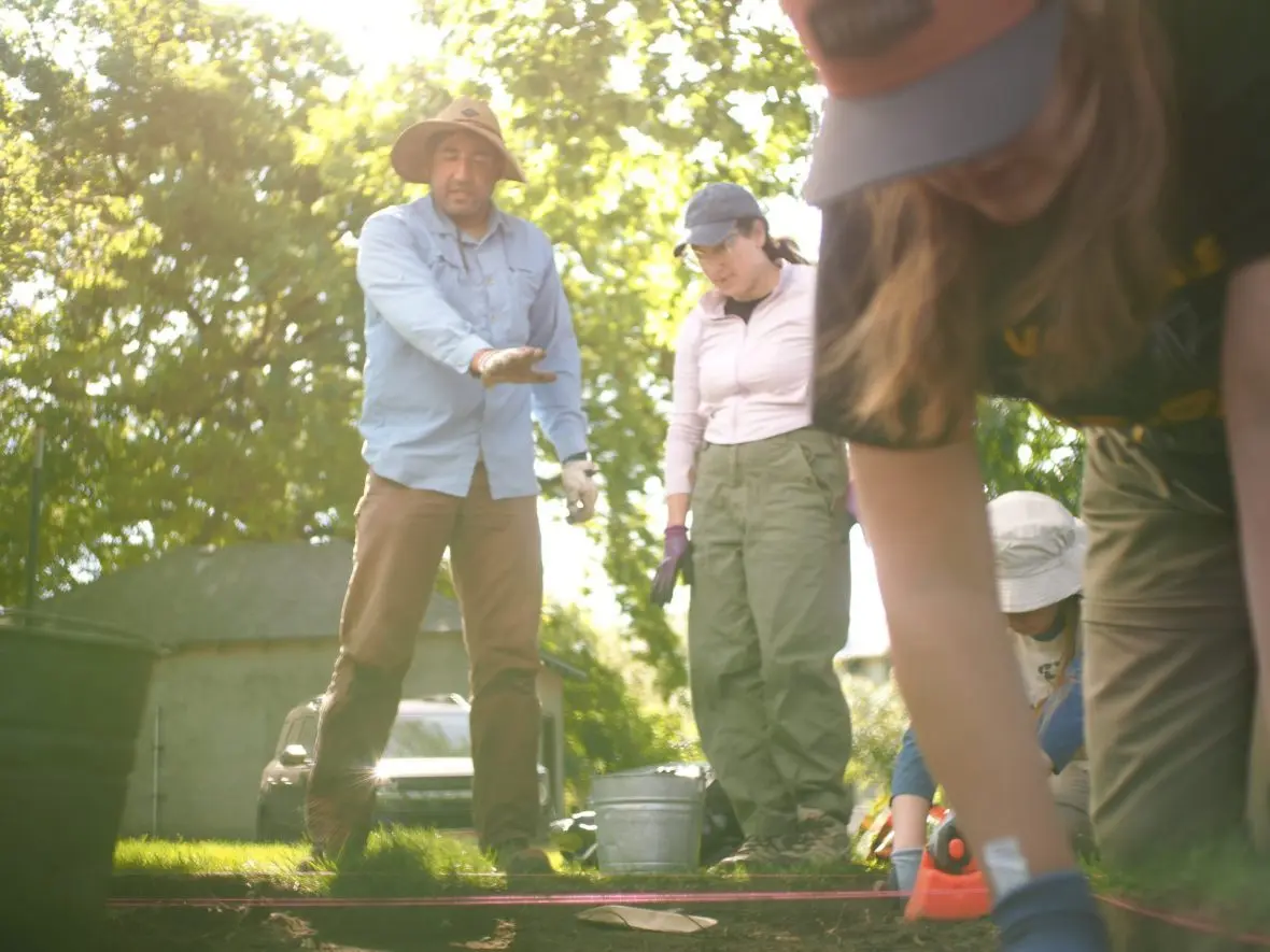 William White, left, speaks with Anna Weissman, center, while they observe the excavation. (Kaeden Lincoln/IdahoEdNews)