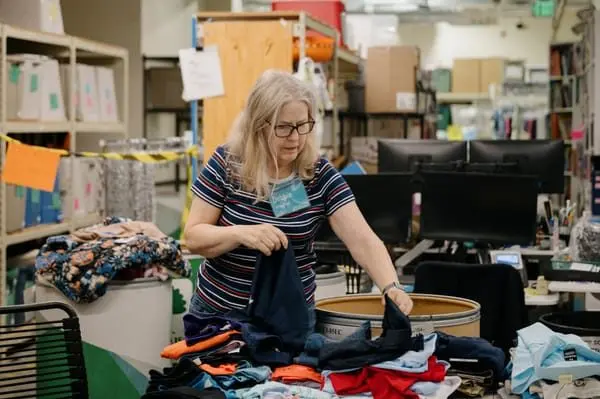 Volunteer Debbie Ohman sorts clothes for the Treehouse Store, a free store where children in foster care can shop. The program is expecting to see a third of its budget cut this year. (Grant Hindsley for Cascade PBS)