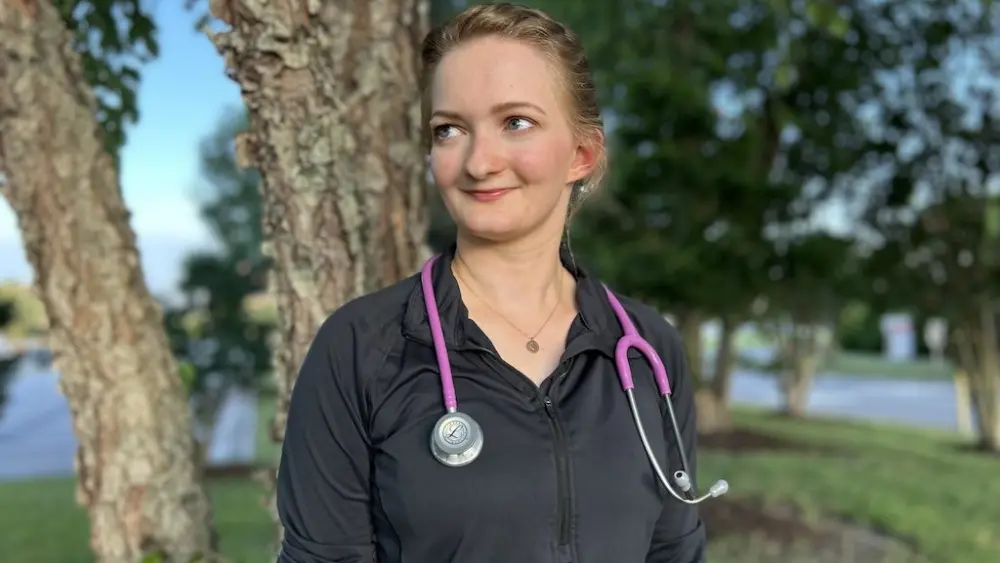 EMT Michaela Bonner stands outside a local hospital in Virginia Beach, Va. Bonner has been working 12-hour shifts for years trying to save up money to go to medical school. But now that President Donald Trump’s signature tax and spending law caps professional student loans, she’s worried her dreams of becoming a doctor are financially out of reach. (Photo by Jnaiah Price)