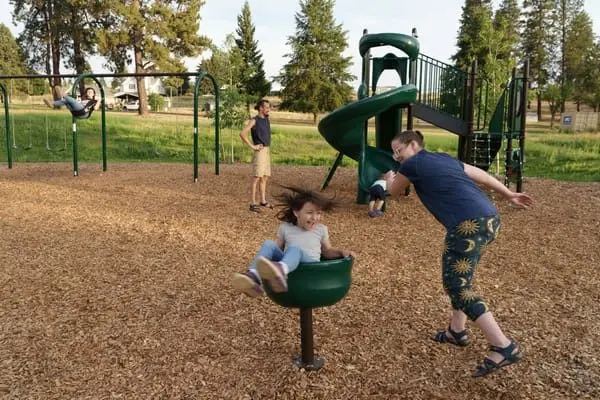 Tiffany Hogg, right, and Kevin Anderson, second from left, play with their three children, including their daughter Wendilyn, 7, center, on July 31 at the Malden Community Park.  (Ted S. Warren for Cascade PBS)