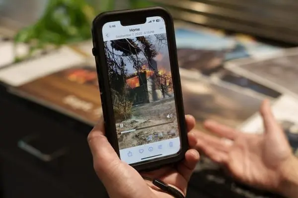 Chandelle Frick watches a video of a neighbor’s home burning in the 2020 wildfire, caused by a tree falling ontp an Avista power line. (Ted S. Warren for Cascade PBS)