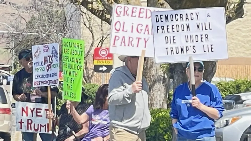Anti-Trump protestors at the corner of Bridge Street and 5th Street in Clarkston on May 1, 2025.