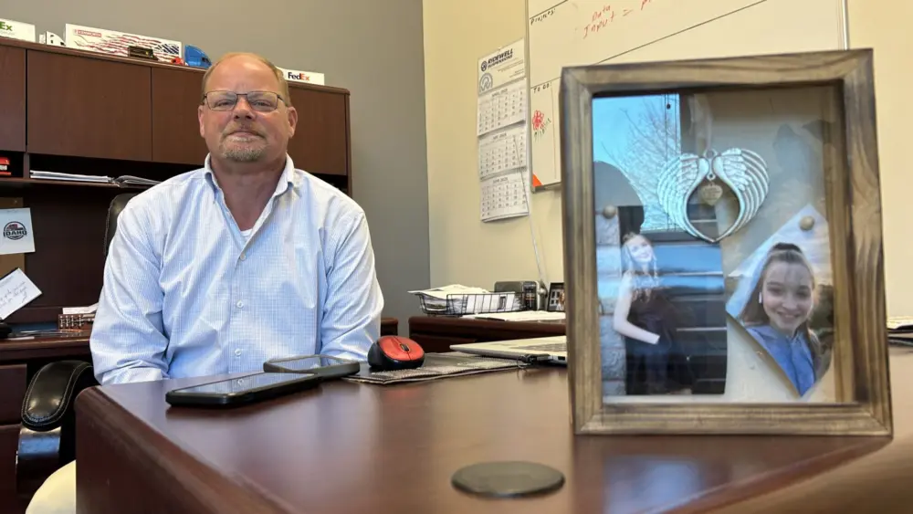 Allen Hodges sits at his desk next to framed pictures of his daughter, Kylie. (Kyle Pfannenstiel/Idaho Capital Sun)