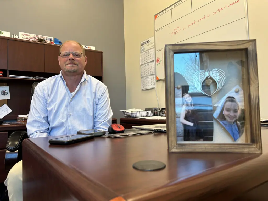 Allen Hodges sits at his desk next to framed pictures of his daughter, Kylie. (Kyle Pfannenstiel/Idaho Capital Sun)