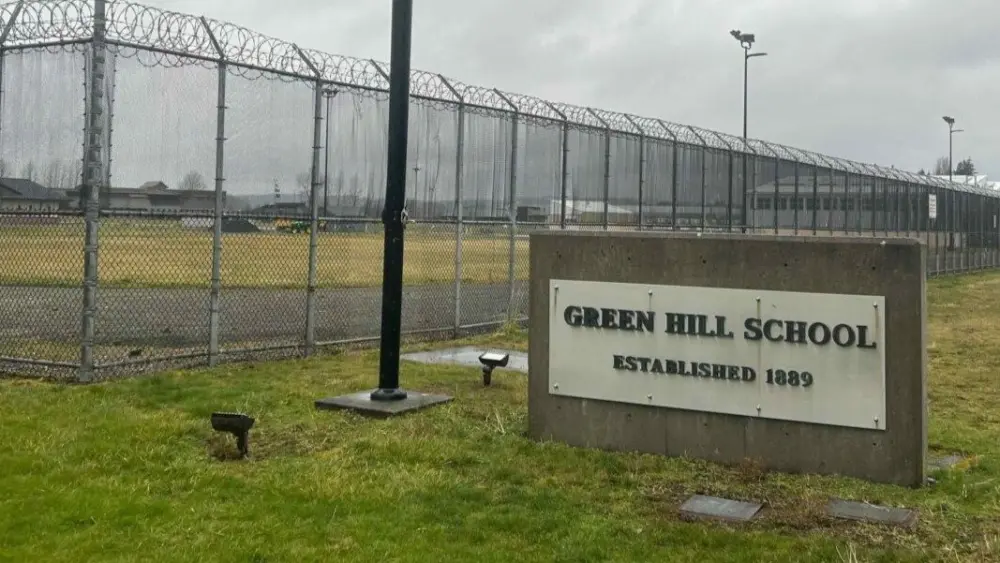 A sign and fence at the Green Hill School for juvenile offenders, in Chehalis, Washington. (Photo by Jake Goldstein-Street/Washington State Standard)