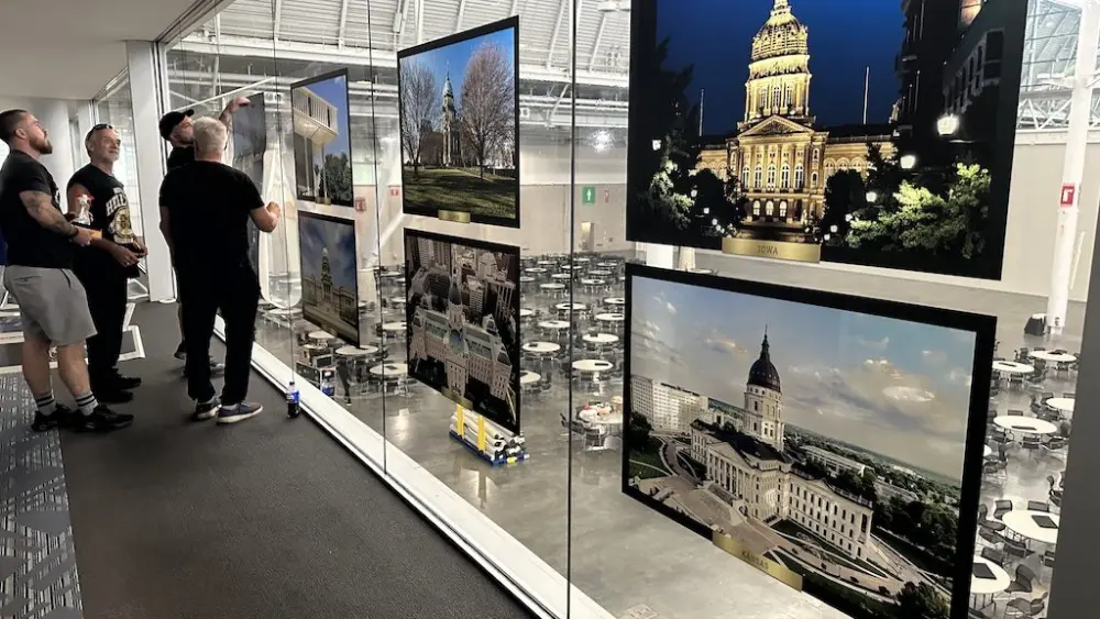 Crews install portraits of state capitol buildings ahead of the National Conference of State Legislatures annual summit on Aug. 4 in Boston. NCSL has asked the Trump administration to stop its review of state laws it says are overly burdensome on business. (Photo by Kevin Hardy/Stateline)