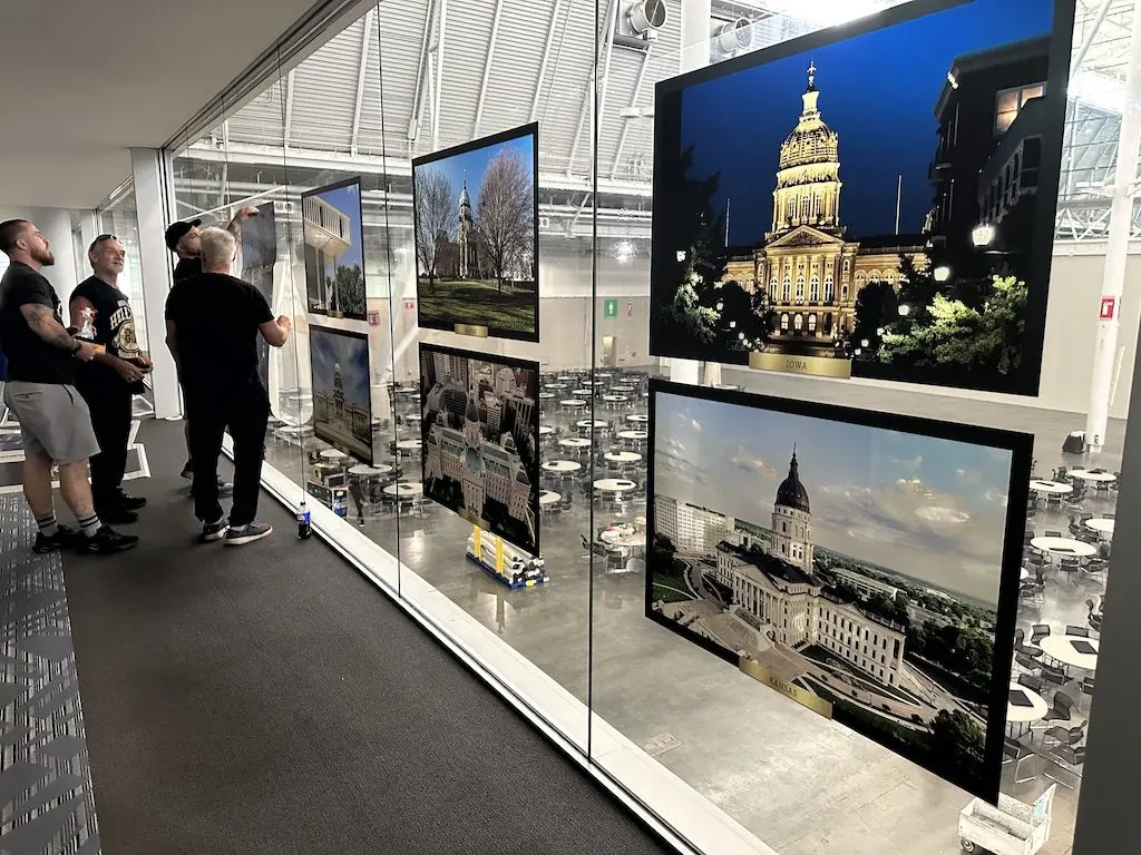Crews install portraits of state capitol buildings ahead of the National Conference of State Legislatures annual summit on Aug. 4 in Boston. NCSL has asked the Trump administration to stop its review of state laws it says are overly burdensome on business. (Photo by Kevin Hardy/Stateline)