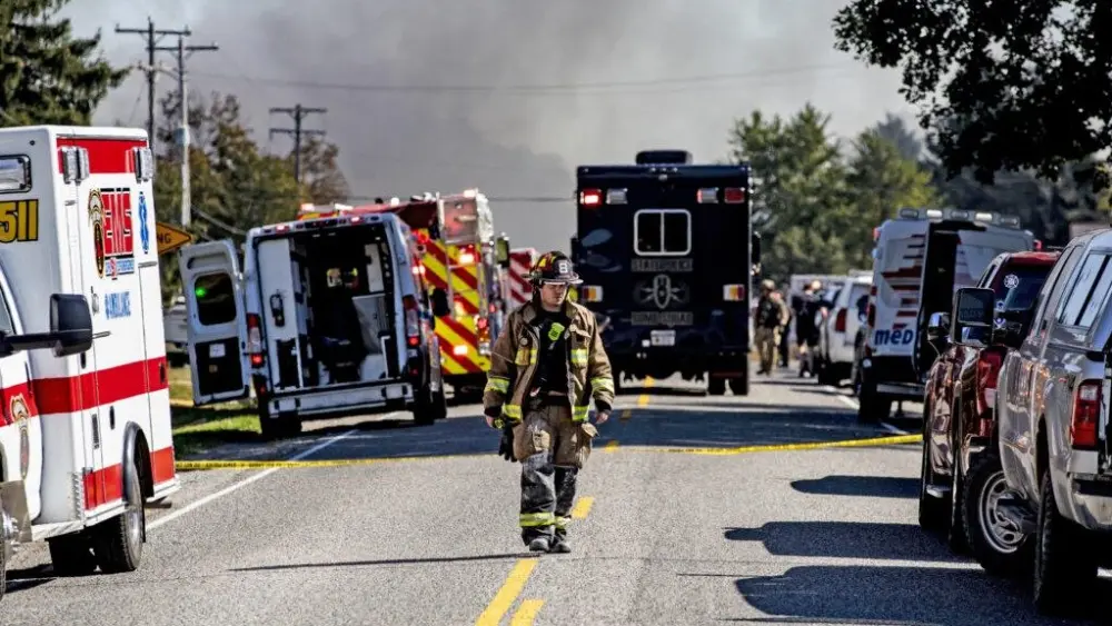 GRAND BLANC, MICHIGAN – SEPTEMBER 28: A firefighter walks down the street where emergency services are responding to a shooting and fire at the Church of Jesus Christ of Latter-day Saints on September 28, 2025 in Grand Blanc, Michigan. According to police reports there are multiple victims and the shooter is down. (Photo by Emily Elconin/Getty Images)