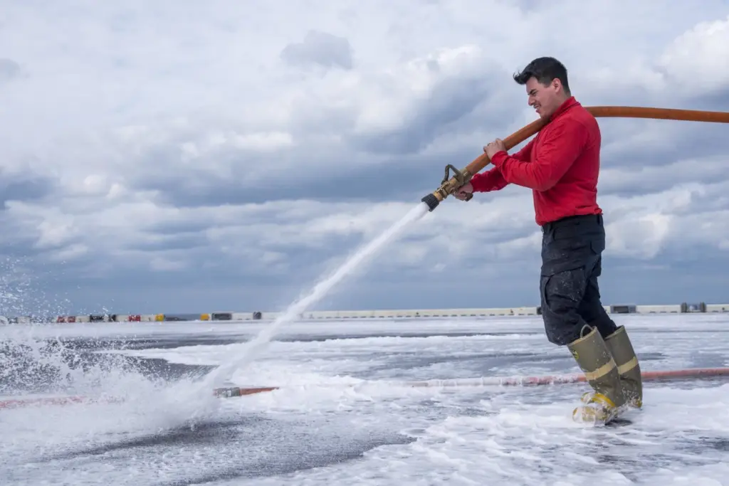 Petty Officer 3rd Class Erick Veracervantes, from Oxnard, Calif., sprays salt water onto the flight deck of amphibious assault ship USS Bonhomme Richard (LHD 6) during an aqueous film forming foam (AFFF) countermeasure washdown. AFFF is a mixture of water and highly concentrated detergent used to smother fires. (U.S. Navy photo by Petty Officer 3rd Class Jeanette Mullinax/Released)
