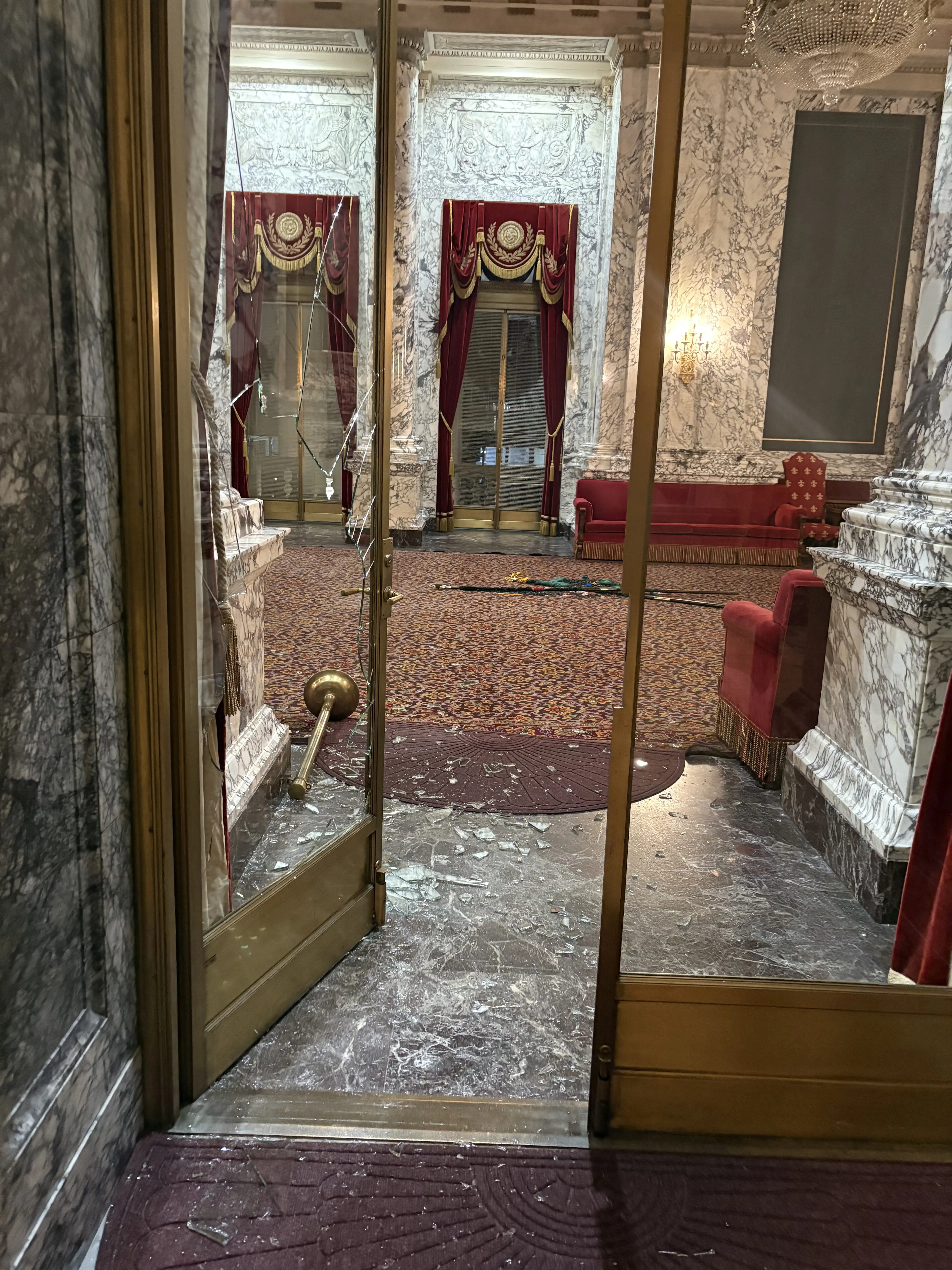 Shattered glass and broken furnishings mark the entrance to the State Reception Room at the Washington State Capitol after a break-in and vandalism incident. Photo Credit: Washington State Department of Enterprise Services