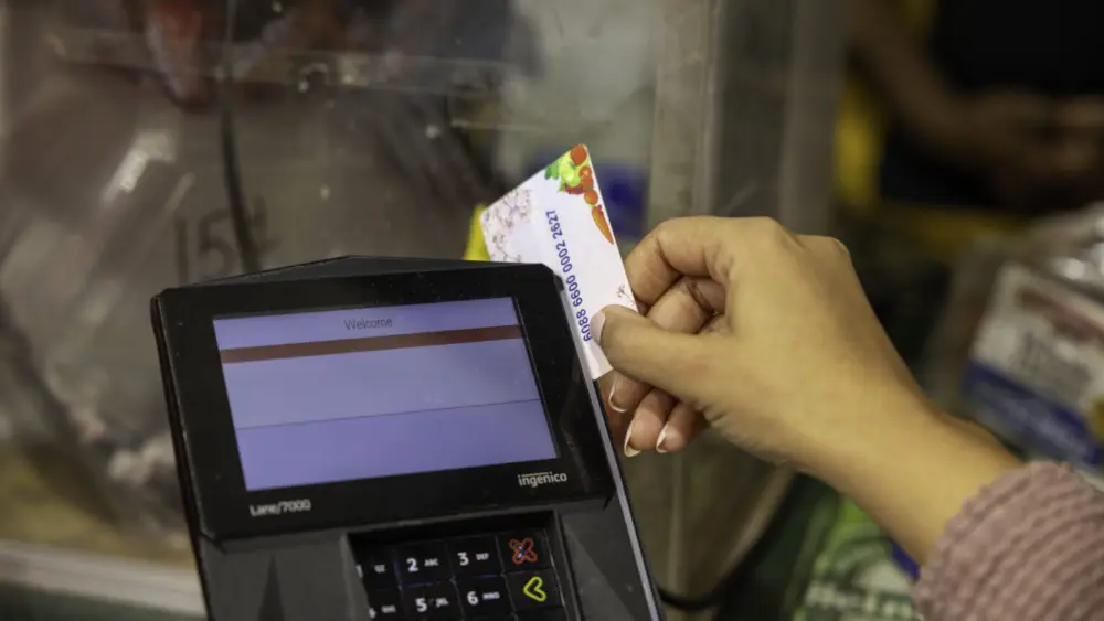 A shopper who receives SNAP benefits slides an EBT card at a checkout counter in a Washington, D.C., grocery store in December 2024. (Photo by U.S. Department of Agriculture)