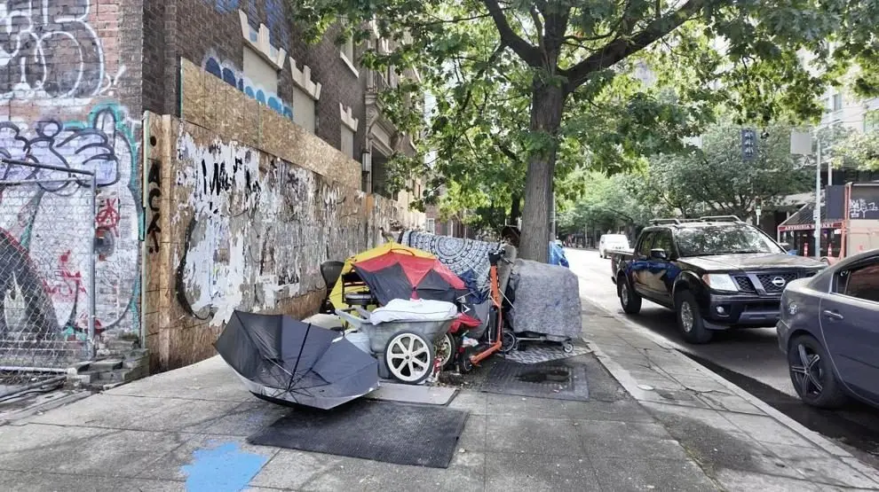 A homeless encampment with personal belongings and makeshift shelter is seen along a sidewalk in Seattle. Photo: Spencer Pauley / The Center Square