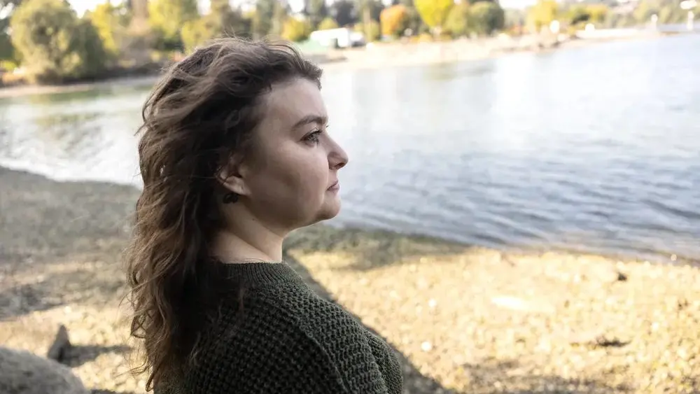 Lauryn Berg, 32, at Evergreen Rotary Park in Kitsap County, Wash. on September 23, 2025. Berg secured a domestic violence protection order against her ex-husband in August 2024, which required him to surrender all of his guns to law enforcement. Although Berg’s ex-husband turned in two handguns, she fears that he can still access other guns he owned during their relationship. (Photo by Mike Kane/InvestigateWest)
