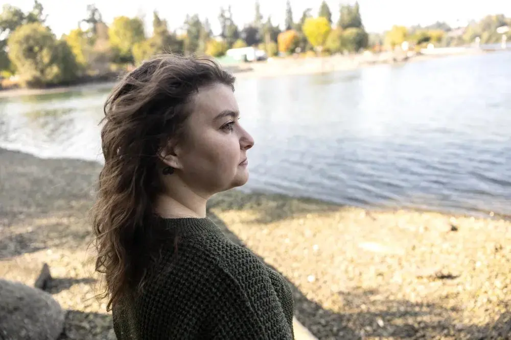 Lauryn Berg, 32, at Evergreen Rotary Park in Kitsap County, Wash. on September 23, 2025. Berg secured a domestic violence protection order against her ex-husband in August 2024, which required him to surrender all of his guns to law enforcement. Although Berg’s ex-husband turned in two handguns, she fears that he can still access other guns he owned during their relationship. (Photo by Mike Kane/InvestigateWest)