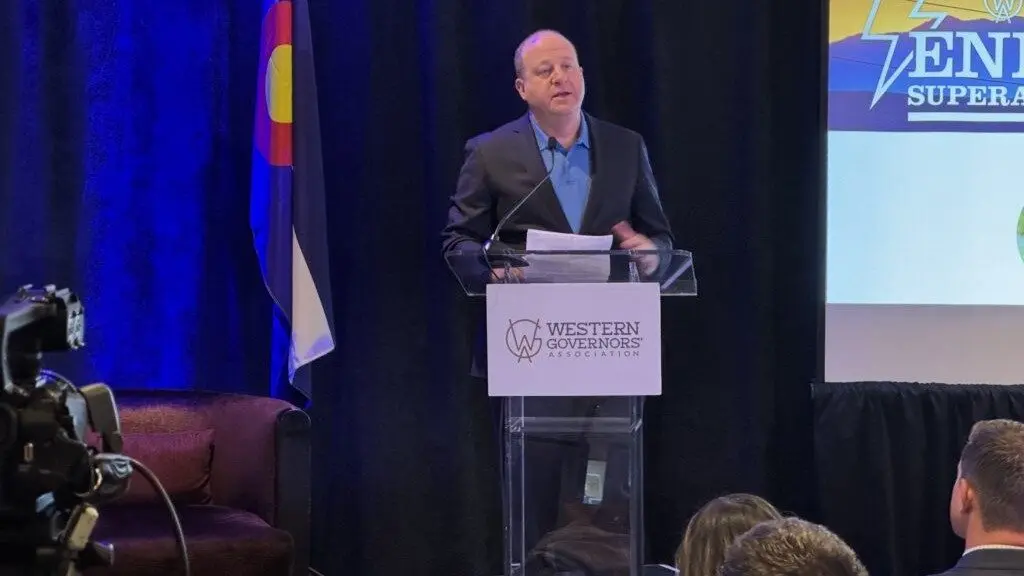 Gov. Jared Polis speaks to policymakers and experts at an energy transmission policy workshop hosted by the Western Governors Association in Denver on Oct. 28, 2025. (Photo by Chase Woodruff/Colorado Newsline)