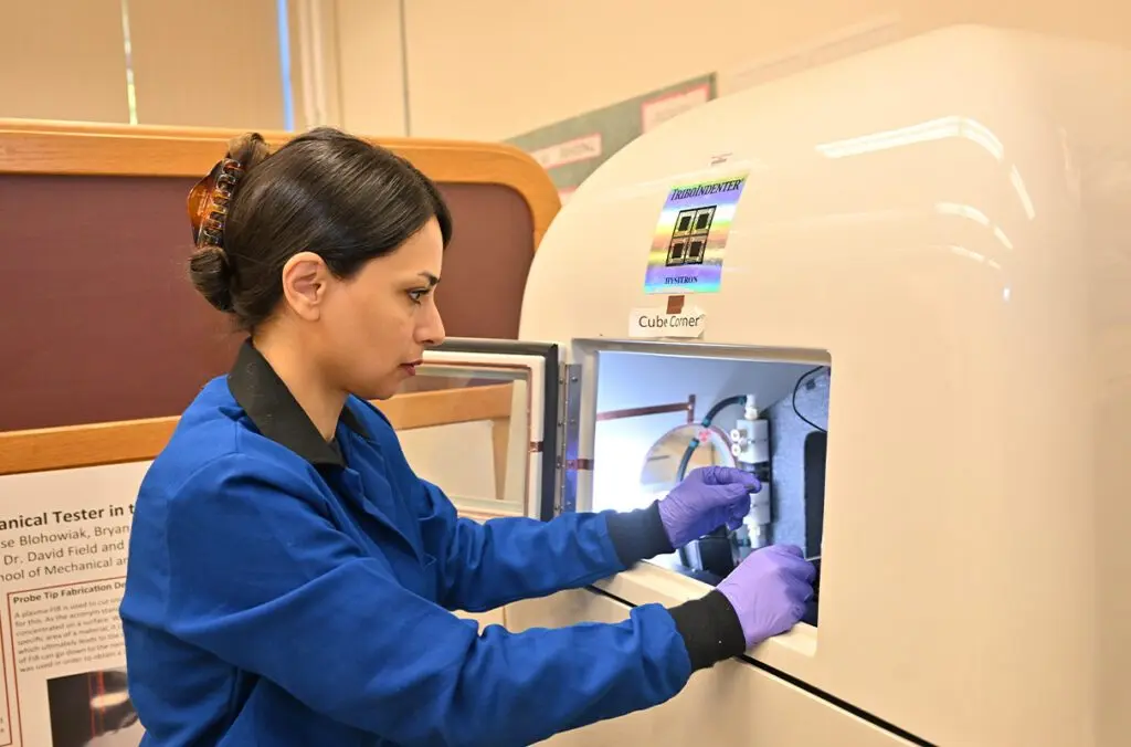 Assistant Professor Arezoo Zare loads a sample into a nano-indenter to evaluate localized mechanical properties (photo by WSU Photo Services).
