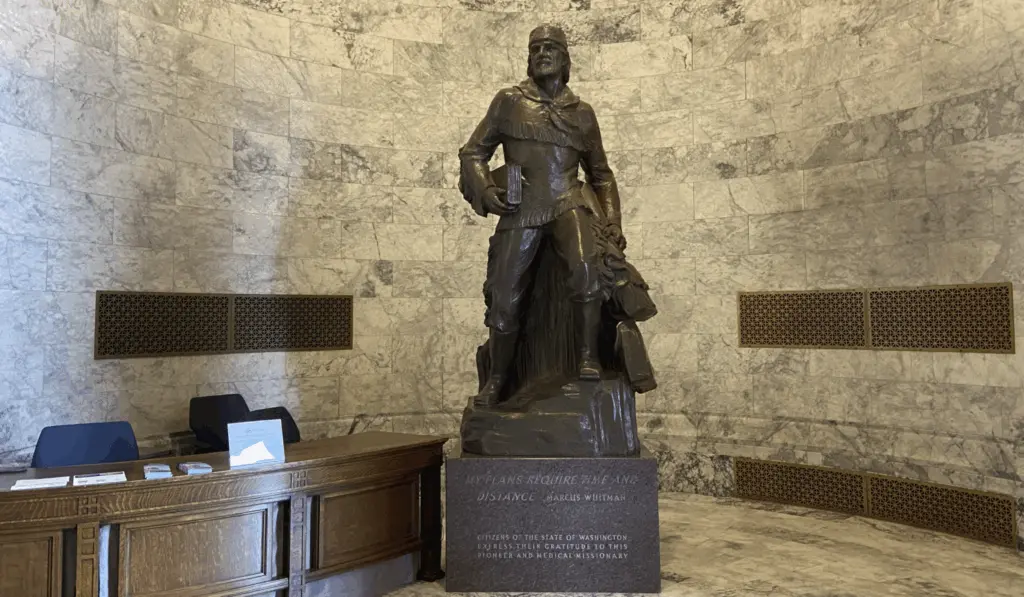 A bronze Marcus Whitman statue in the Washington state Capitol building weighs over 9,000 pounds with its stone base. (Jacquelyn Jimenez Romero/Washington State Standard)