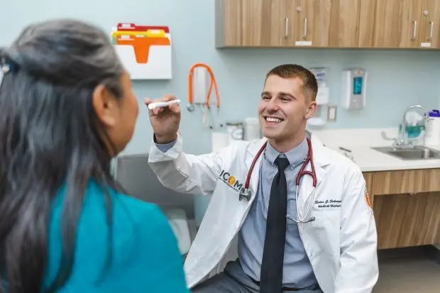 During a simulated clinical encounter, Idaho College of Osteopathic Medicine student physician Quinn Schroeder practices performing an eye exam using a pupil light to evaluate pupillary reflexes. (ICOM photo)