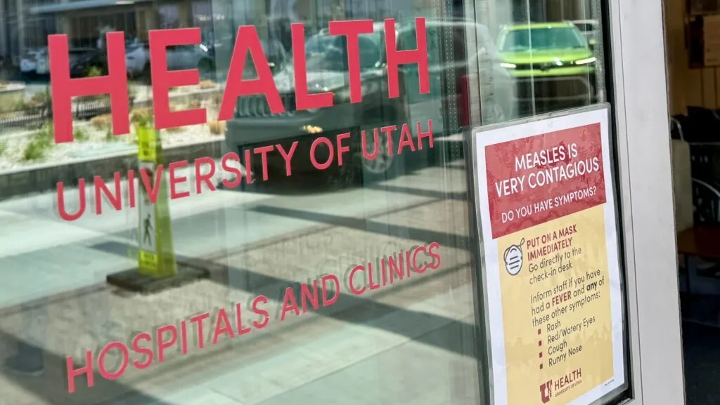 A University of Utah health clinic with a sign warning of measles is pictured in Salt Lake City on June 30, 2025. (McKenzie Romero/Utah News Dispatch)