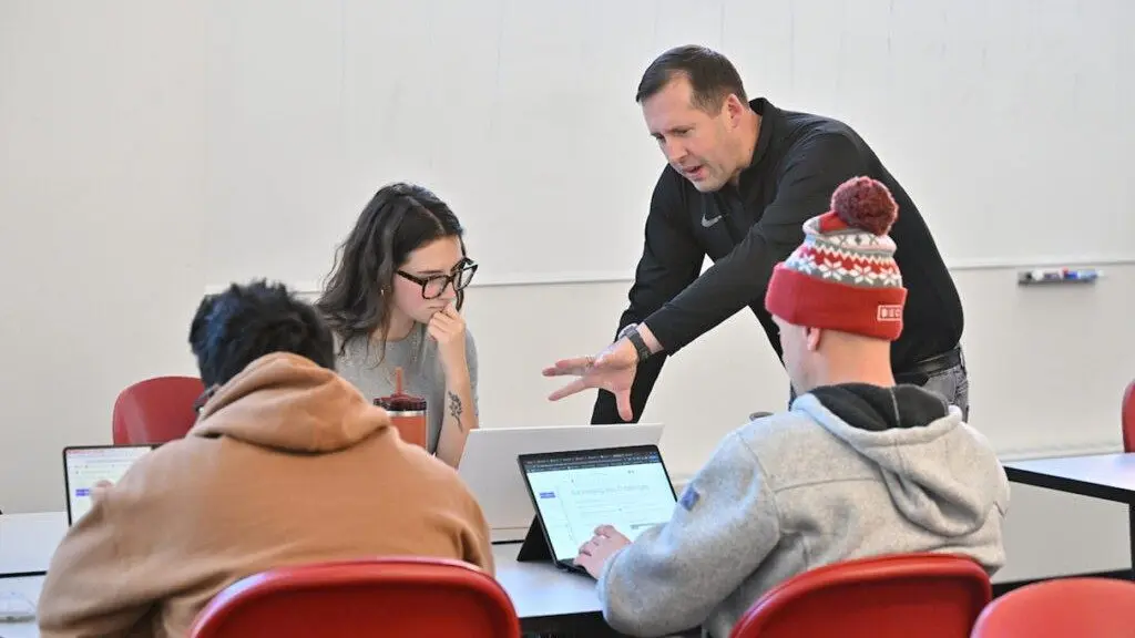 Professor Robert Crossler works with WSU student Eden Brooks and her teammates during the AI @ Carson Workshop on Nov. 2 at Spark Academic Innovation Hub on the WSU Pullman campus (photo courtesy of the Carson College of Business).