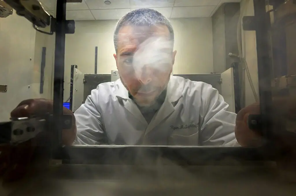 Ryan McLaughlin, an associate professor in the Department of Integrative Physiology and Neuroscience in WSU's College of Veterinary Medicine, looks into a clear box used for cannabis vapor research (photo by Ted S. Warren, College of Veterinary Medicine).