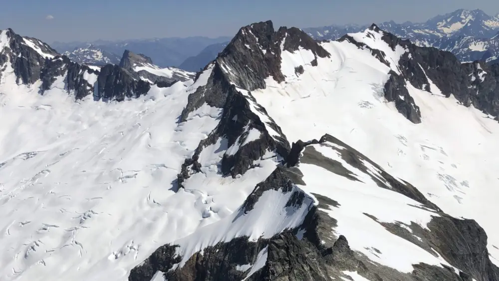 he Boston Glacier, left, viewed from Forbidden Peak, falls away from Boston Peak in the North Cascades. Boston Basin to the right. (Bill Lucia/Washington State Standard)