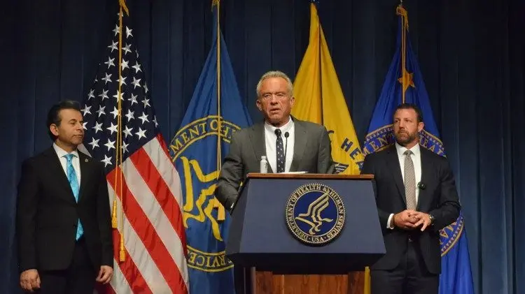 FDA Commissioner Marty Makary and Sen. Markwayne Mullin listen as Health and Human Services Secretary Robert F. Kennedy Jr. speaks at a press conference in Washington, July 29, 2025. Photo: Andrew Rice / The Center Square