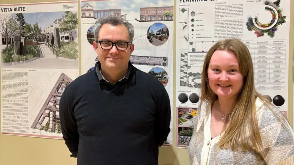 Professor Dan Cronan (left) Ella Roney stand in front of schematics detailing Roney's landscape design (photo courtesy of Ella Roney).