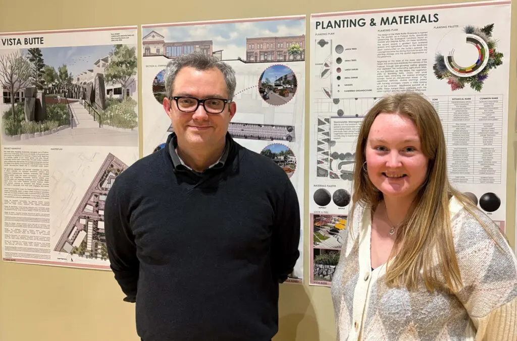 Professor Dan Cronan (left) Ella Roney stand in front of schematics detailing Roney's landscape design (photo courtesy of Ella Roney).