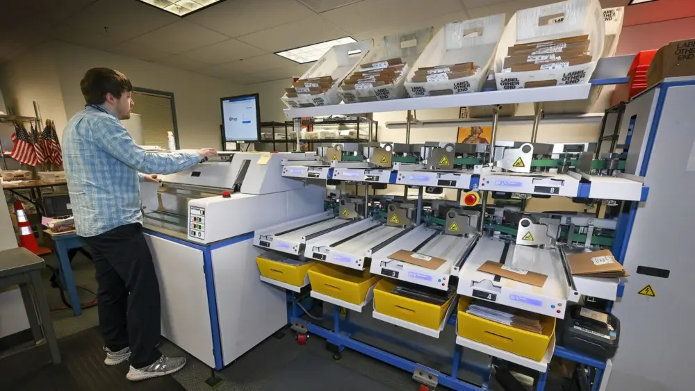 Ryan Patraw process ballots at the Marion County Clerk’s Office in Salem on Monday, May 16. Each ballot goes through several steps before it is scanned to have the vote tabulated. (Photo by Ron Cooper/Oregon Capital Chronicle)