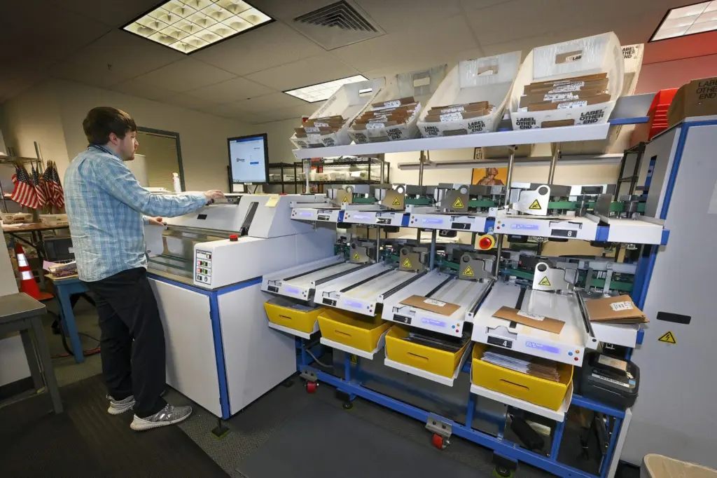 Ryan Patraw process ballots at the Marion County Clerk’s Office in Salem on Monday, May 16. Each ballot goes through several steps before it is scanned to have the vote tabulated. (Photo by Ron Cooper/Oregon Capital Chronicle)