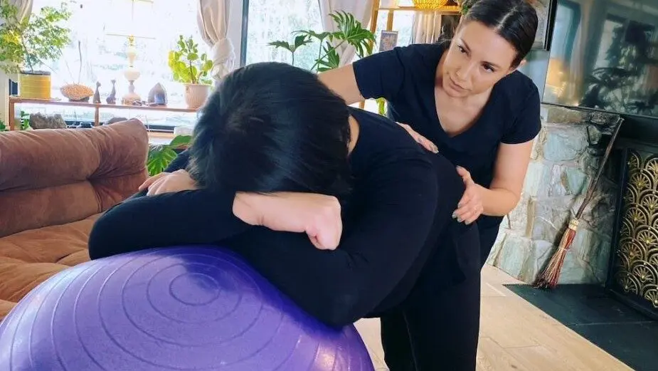 Founder of Eggbaby Doula Services Aleece Weaver, right, demonstrates the work she does with pregnant clients. Weaver does pro bono doula care with clients in recovery at Utah perinatal recovery clinic SUPeRAD. Peer recovery doulas help moms with addiction, and state Medicaid plans have been expanding to cover doula care. (Photo by Anna Shmynets)Founder of Eggbaby Doula Services Aleece Weaver, right, demonstrates the work she does with pregnant clients. Weaver does pro bono doula care with clients in recovery at Utah perinatal recovery clinic SUPeRAD. Peer recovery doulas help moms with addiction, and state Medicaid plans have been expanding to cover doula care. (Photo by Anna Shmynets)