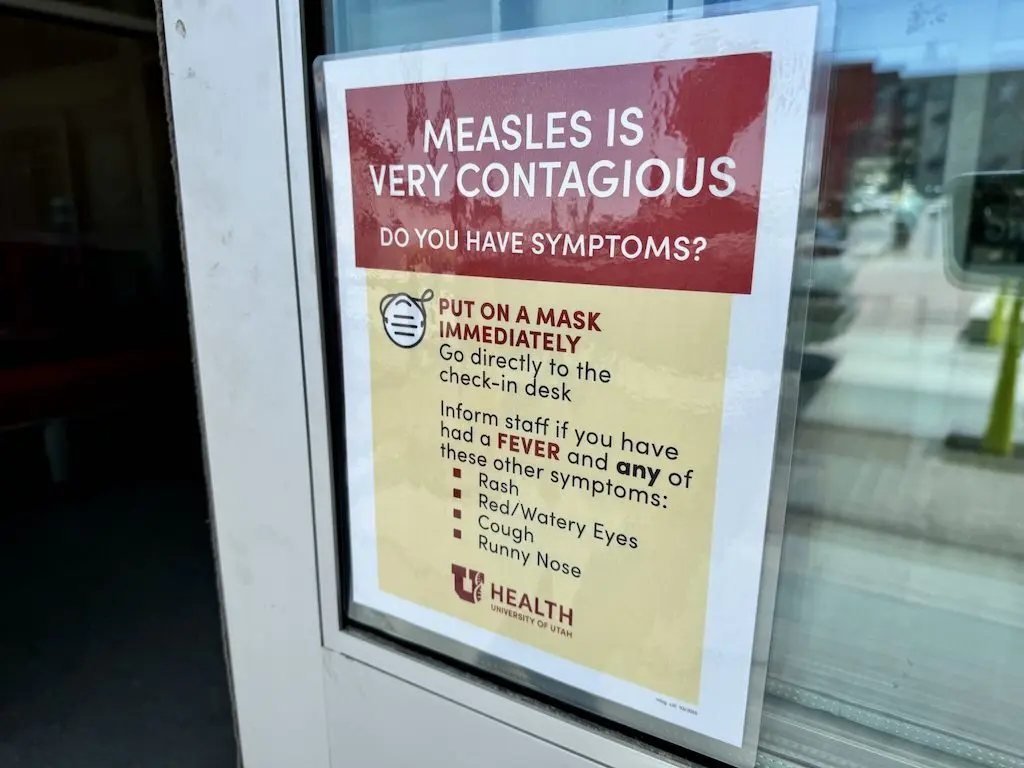 A sign at a University of Utah health clinic warns visitors about the spread of measles. Under the Trump administration, federal health officials have cut back the number of recommended vaccines, and more states are offering exemptions for parents who don’t want to vaccinate children entering public schools. (Photo by McKenzie Romero/Utah News Dispatch)