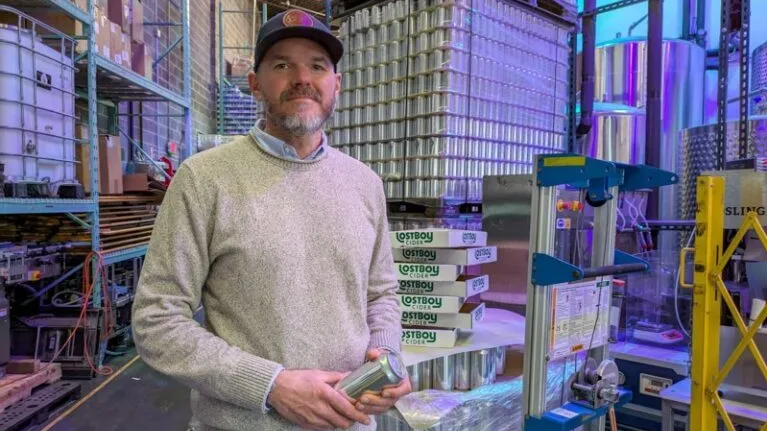 Tristan Wright, founder and president of Lost Boy Cider, stands near his production line on Feb. 6, 2026, in Alexandria, Virginia. (Photo by Ashley Murray/States Newsroom)
