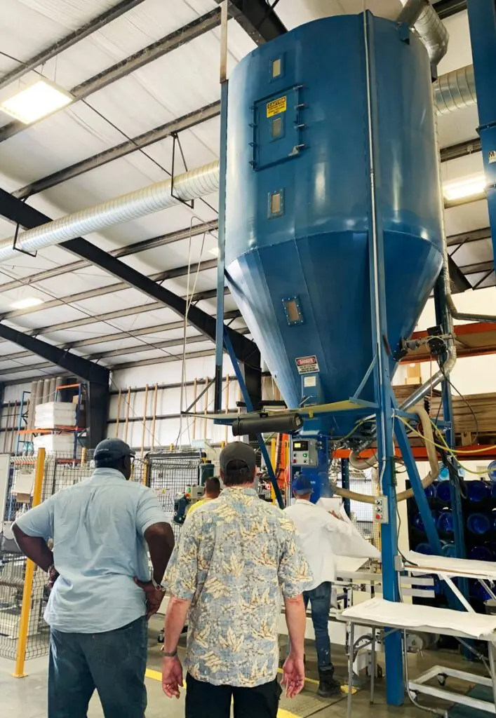 WSU professor Michael Neff and “Ask This Old House” co-host Lee Gilliam watch as Jason Miller, one of the owners of Himark Seeds, demonstrates how grass seed is processed (photo courtesy of Paula Lundt, Seed Program Manager, Washington State Department of Agriculture).