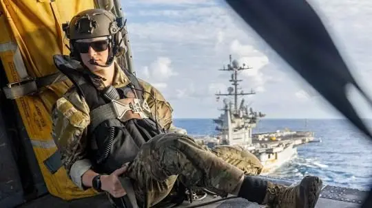 Navy sailor monitors MH-60S Sea Hawk approach during ammo offload in Atlantic, Aug. 5, 2025. Navy Petty Officer 3rd Class Abel Blaze monitors the approach of an MH-60S Sea Hawk to the USNS Robert E. Peary during an ammunition offload in the Atlantic Ocean on Aug. 5, 2025. Photo: Navy Seaman Michael Gomez / U.S. Department of Defense / United States Government Work
