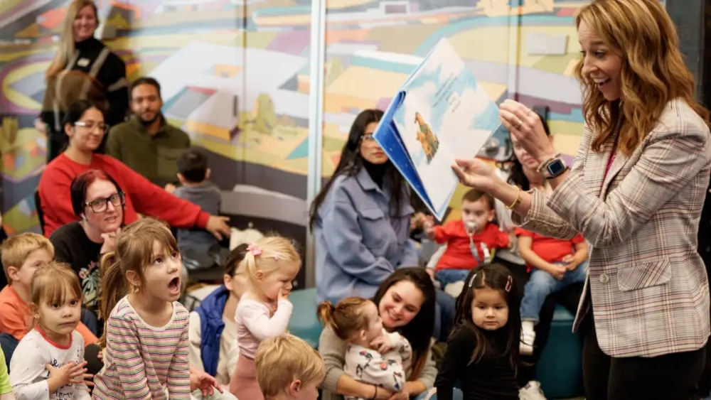 First Lady Abby Cox reads to children gathered for a story hour after she and Gov. Spencer Cox held a press conference to present his budget proposal at the Salt Lake County Library in Kearns on Wednesday, Dec. 3, 2025. (Photo by Spenser Heaps for Utah News Dispatch)