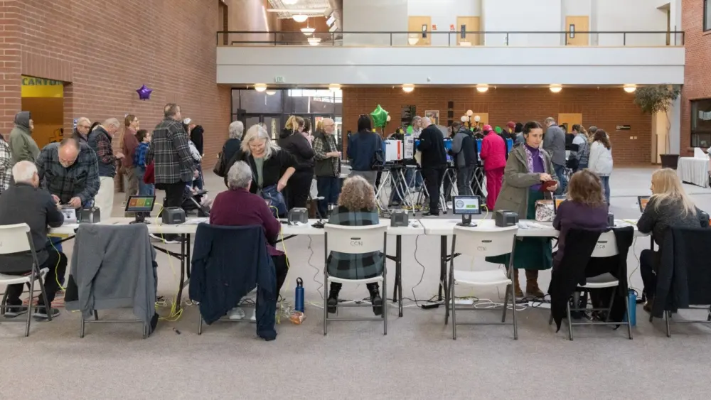 Seated poll workers help Canyon County voters at a polling place at the College Church of the Nazarene on the NNU campus in Nampa, Idaho, on Nov. 8, 2022. (Photo by Otto Kitsinger for Idaho Capital Sun)