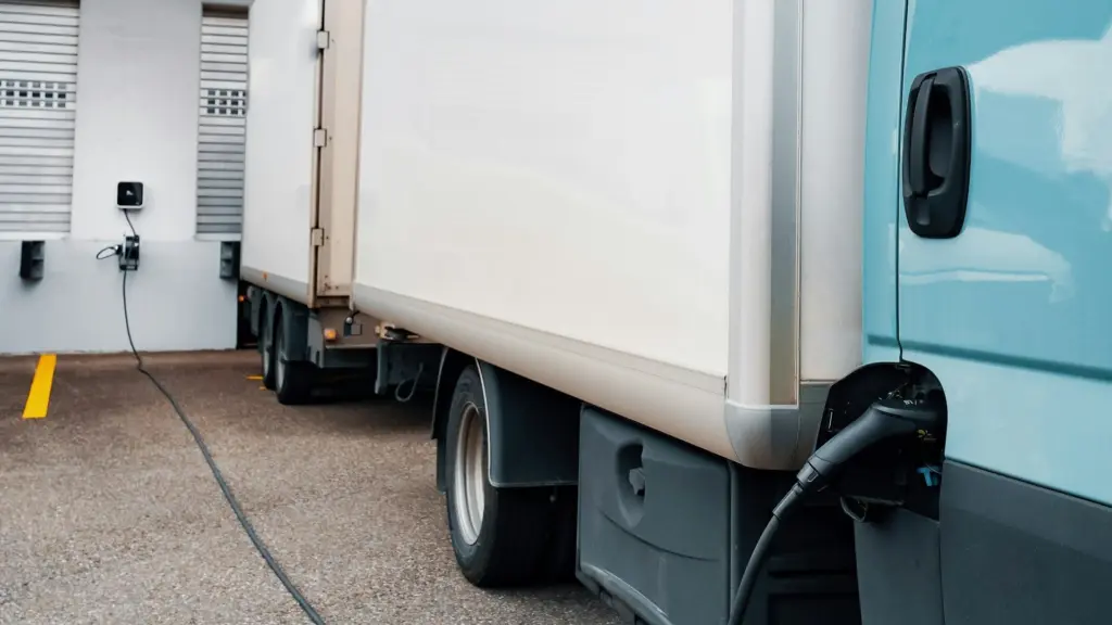 An electric commercial truck is shown charging at a facility. Washington’s proposed $112 million voucher program is aimed at increasing adoption of medium- and heavy-duty electric vehicles, while infrastructure remains a key challenge. Photo by JUICE on Unsplash