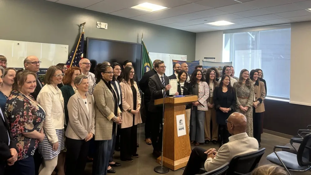 Washington Gov. Bob Ferguson stands alongside lawmakers and housing advocates after signing House Bill 2266 into law on Friday, March 27, 2026, in Everett. (Photo by Jake Goldstein-Street/Washington State Standard)