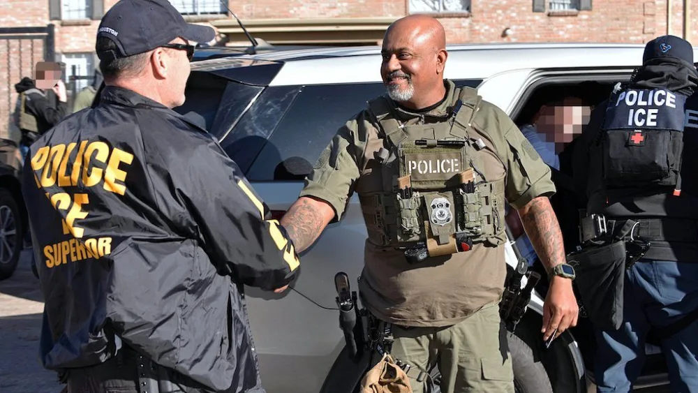 Houston-based immigration officials greet each other after December arrests involving the smuggling of immigrants on a tractor trailer. A revived “task force” cooperation program will let state and local law enforcement coordinate with the Trump administration on immigration arrests during routine police work. (Photo courtesy of U.S. Immigration and Customs Enforcement)