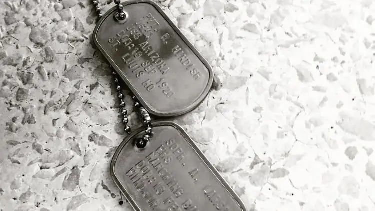 A pair of military dog tags rests on a textured surface. Photo: Sarah Roderick-Fitch / The Center Square