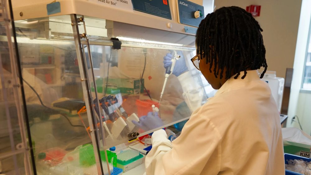 Dora Nabatanzi, a molecular biologist at the Broad Institute, prepares chemicals needed to sequence the genomes of measles viruses. (Amy Maxmen/KFF Health News)