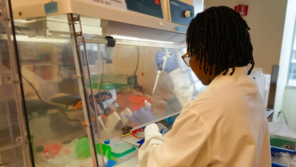 Dora Nabatanzi, a molecular biologist at the Broad Institute, prepares chemicals needed to sequence the genomes of measles viruses. (Amy Maxmen/KFF Health News)
