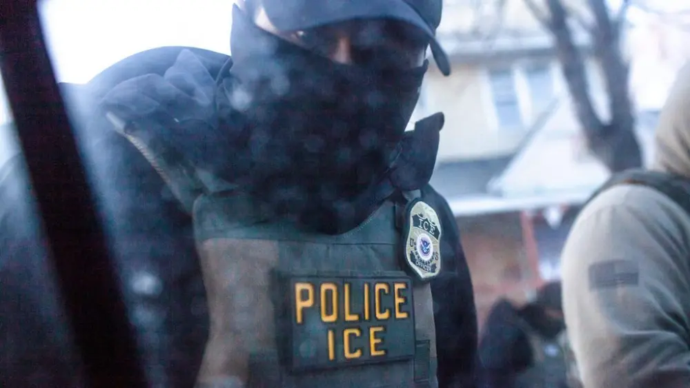 A masked U.S. Immigration and Customs Enforcement agent knocks on a car window in Minnesota on Jan. 12. (Photo by Nicole Neri/Minnesota Reformer)