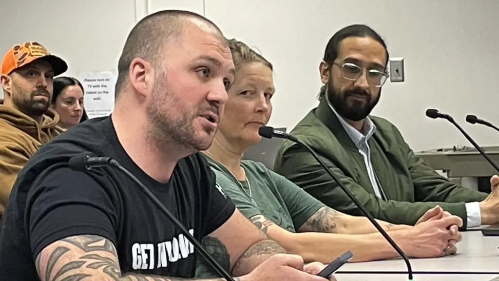 Cory Maxwell of Kitsap County (left) called on some members of the Washington Fish and Wildlife Commission to step down in public comments on April 17, 2026. Rachel Bjork and Francisco Santiago-Avila look on. (Photo by Jerry Cornfield/ Washington State Standard)