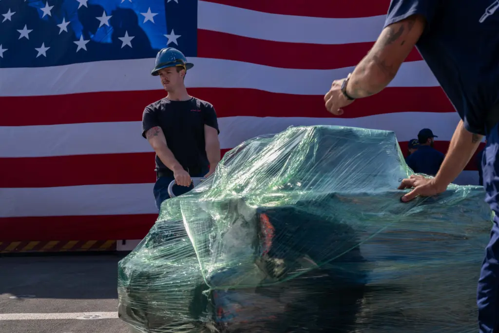 Boatswain’s Mate 2nd Class Carson Williams moves a pallet of seized cocaine aboard the Coast Guard cutter Kimball in San Diego on April 24, 2025. Photo: Petty Officer 3rd Class Austin Wiley / U.S. Coast Guard via DVIDS / Public Domain