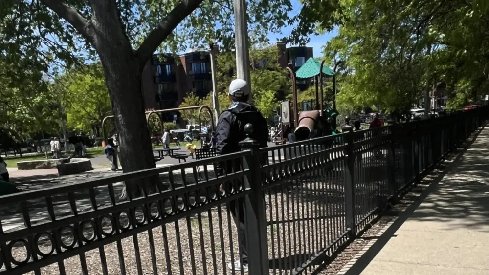 A teacher observes students playing at a Chicago school playground. Many states are grappling over who should be required to report incidents of child neglect and abuse. (Photo by Robbie Sequeira/Stateline)