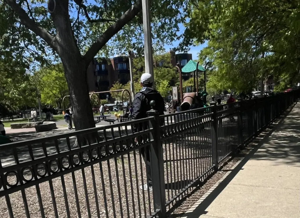 A teacher observes students playing at a Chicago school playground. Many states are grappling over who should be required to report incidents of child neglect and abuse. (Photo by Robbie Sequeira/Stateline)